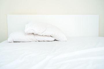 Fototapeta na wymiar Double white pillows on the white sheet bed