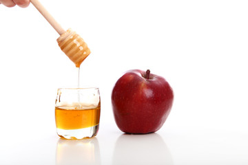 honey jar with red apple white background studio