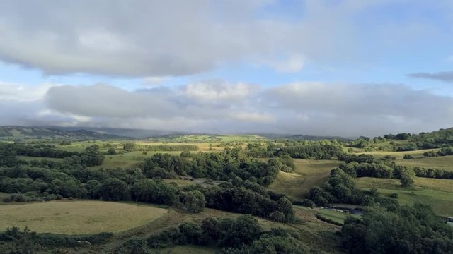 Aerial view, rise up move. Drone panorama of green fields near Llyn Celyn water reservoir in Wales. Traweryn river