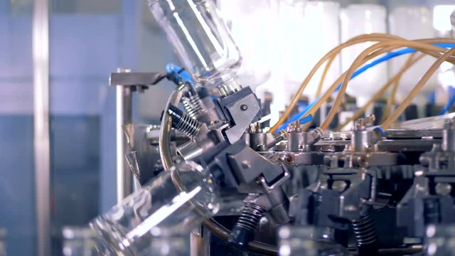 Process of bottle washing at a factory. Automated industrial equipment.