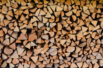 Firewood pile stacked chopped wood trunks for winter heating fireplace