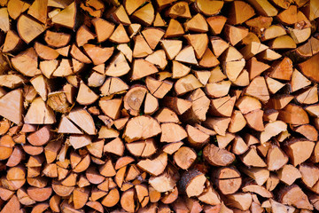 Firewood wooden logs chopped trunks stacked pile drying for winter fireplace background