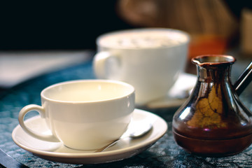 Cup of coffee with turk on the table in cafe or coffee shop. Retro vintage effect picture.