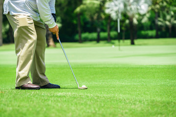 Golf putter putting athletes to hit a golf ball into the hole to reach the goal.