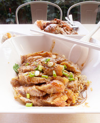 grilled pork roast with yellow or chinese noodle in white a bowl, street food concept