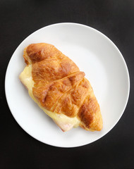 top view of ham and cheese sandwich on white plate