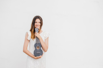 Young smiling beautiful woman with ukulele