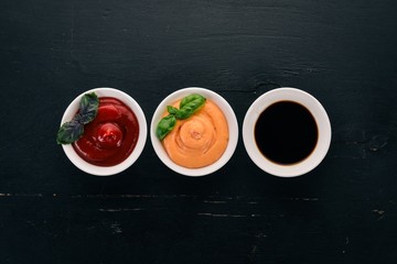 Three sauces in saucers. Ketchup, soy sauce, paprika sauce. Top view. Free space for text.