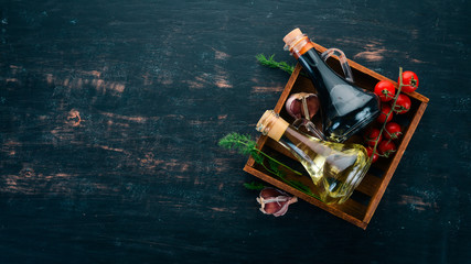 Olive oil and soy sauce in glass jars. Spices and Sauce. Top view. On a black wooden background....
