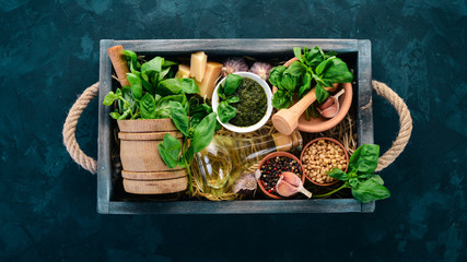 Ingredients for cooking Pesto sauce in a wooden box. Basil, parmesan cheese, olive oil, pine nuts,...
