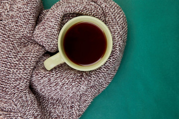 Knitted scarf with warm  cup of tea