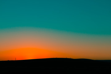 Landscape of dark mountains under blue and orange sunset