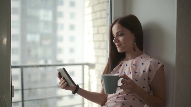 Woman is Watching Movie on Tablet and drink coffee