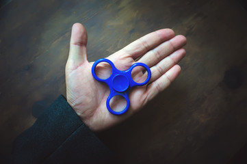 Relieving stress, relaxing at work, copy space, on the background of wooden table. Antistress toy...