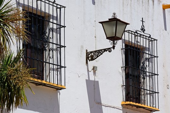Windows on the front right hand side of the Las Angustias Parish church (Parroquia De Nuestra Senora De Las Angustias) with wrought iron grills topped with crosses, Ayamonte, Spain.