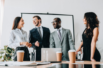 smiling multicultural business people having business meeting in office