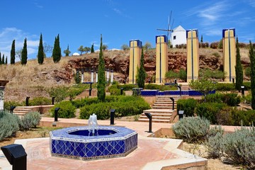 Modern blue tiled fountain at the top of the hill with a traditional white windmill to the rear, Castro Marim, Algarve, Portugal.