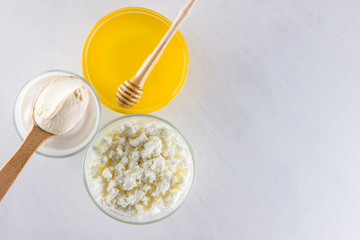 Dairy products and honey with wooden cutlery. Cottage cheese, sour cream, cream on a white background top view. Different organic products for vegan. Healthy food