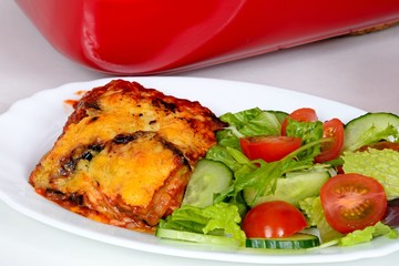 Baked layers of aubergine, cheese and tomato topped with melted cheese served with salad.