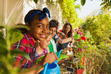 Cute girl with watering can working in garden