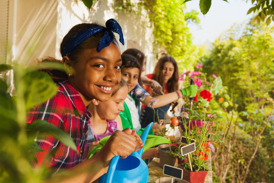 Cute Girl With Watering Can Working In Garden