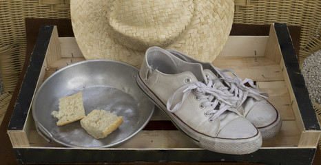 Plato casi vacio junto a unas zapatillas viejas y rotas.