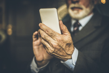 Senior businessman using mobile phone. Close up image.