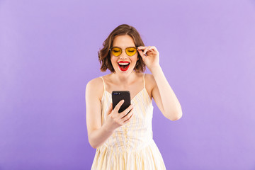 Excited young woman using mobile phone