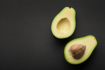 fresh green avocado isolated on dark background. top view