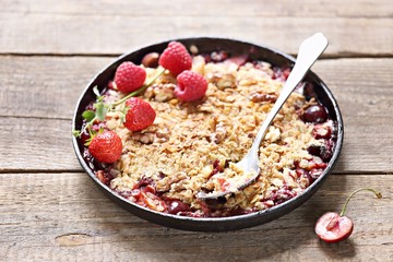 Oatmeal crumble with fresh berries and walnuts. Gluten free summer berries crisp. Selective focus