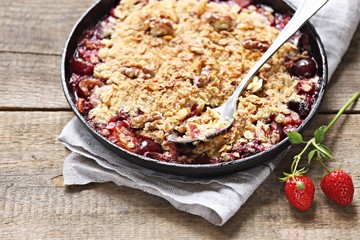 Oatmeal crumble with fresh berries and walnuts. Gluten free summer berries crisp. Selective focus