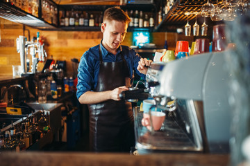 Male bartender prepares drink at the bar counter