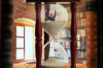 Man drowning inside an hourglass, deadline concept