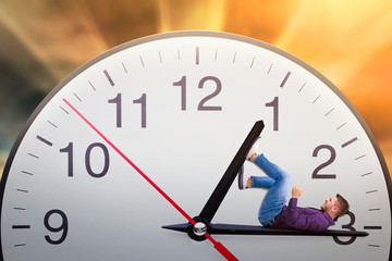 Man lies on the arrow of a huge clock 