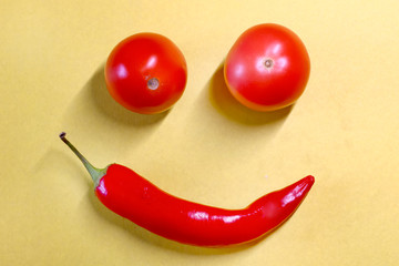 red hot chili pepper and tomato close-up on a colored background