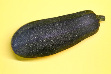 ripe zucchini closeup on a yellow background