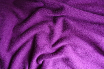 Fototapeta na wymiar Folded bright violet simple woolen knitted fabric