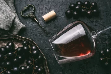 Crédence en verre imprimé Vin Red wine concept with glass, grapes and vintage corkscrew on dark background, top view