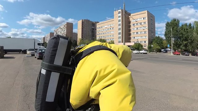 The rescuer in a suit of chemical protection puts on a snyaryazheniye for an entrance to a pollution zone.