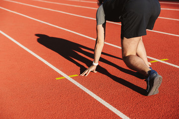 Motivated young sportsman getting ready to run