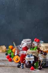 Assortment of seasonal berries and fruits jams in jars