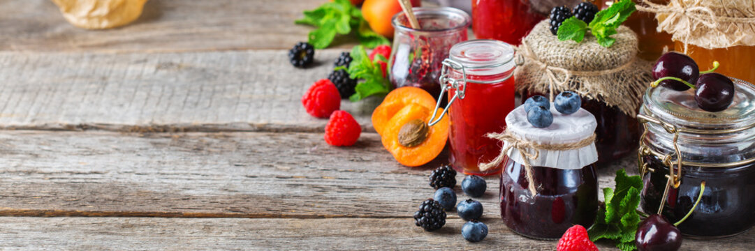 Assortment Of Seasonal Berries And Fruits Jams In Jars