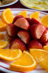 Fototapeta na wymiar Fruit plate with cut oranges and strawberries