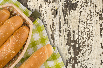 Buns in a wicker basket on old wooden table.