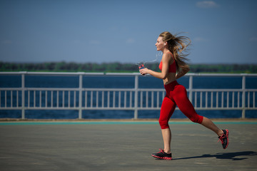 Young fitness woman running on the coast. The concept of a healthy lifestyle