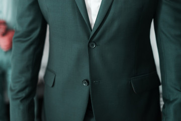 Close up of a mans waistcoat with one button untied.