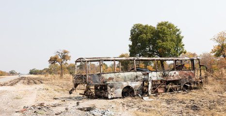 Burned bus at the side of the road