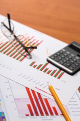 office documents with a pencil, calculator, and eye glasses