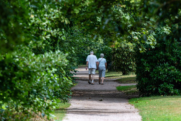 älteres Ehepaar geht in einem Park spazieren - Hand in Hand