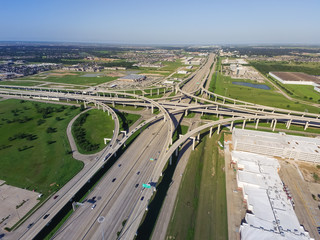 Top view Interstate 10 or Katy freeway with massive intersection, stack interchange, elevated road junction overpass in daytime with clear blue sky. Aerial metropolitan area of Katy, Texas, US - obrazy, fototapety, plakaty